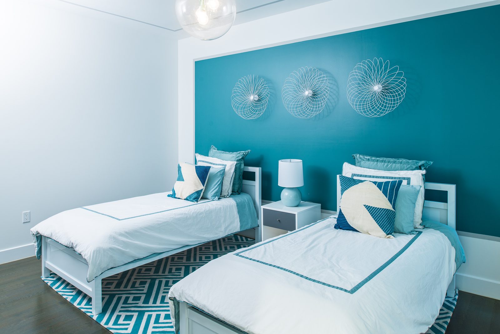Teal themed twin bedroom with spirograph wall art
