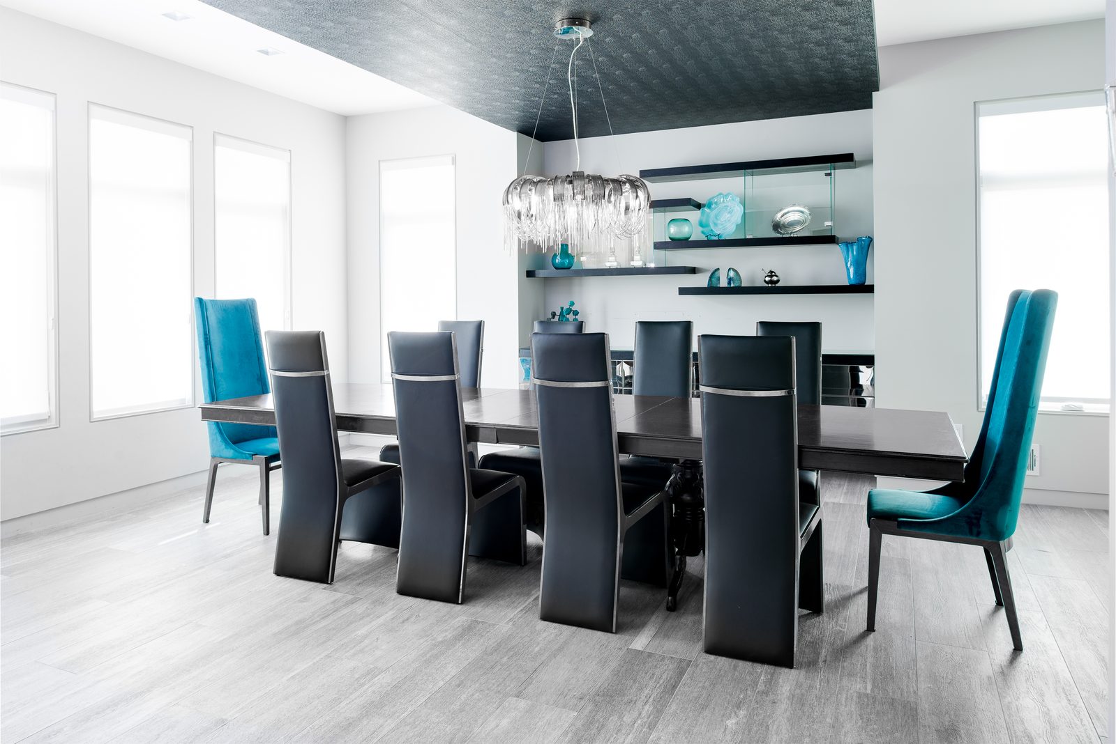 Formal dining room with crystal chandelier and teal chairs