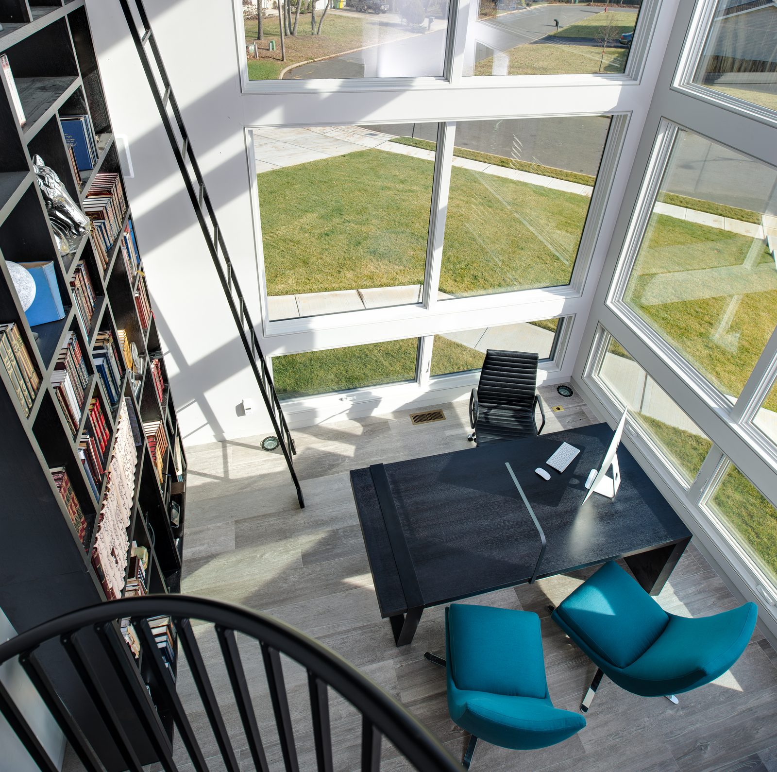 Double-height library with spiral staircase and rolling ladder
