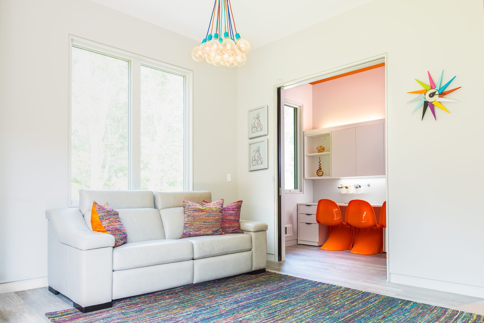 Kids playroom with orange Panton chairs and colorful chandelier